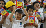 A group of children holding up the ACN child bible