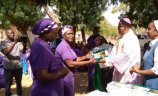 Catechists being gifted a bible from priest and Sister