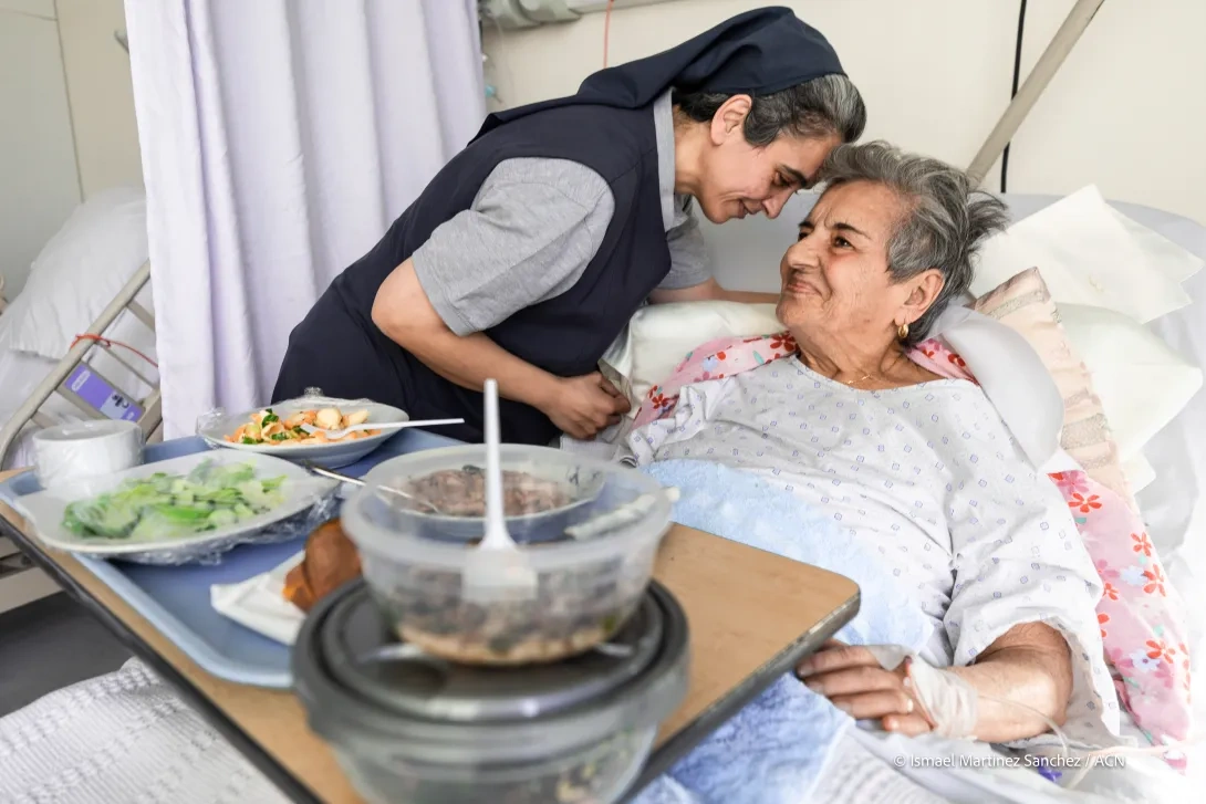 A Sister help an elderly woman in hospital