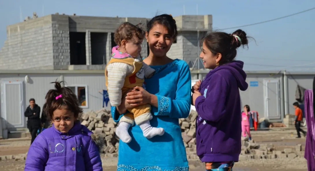 A Christian mother stands with her children and baby in the Middle East