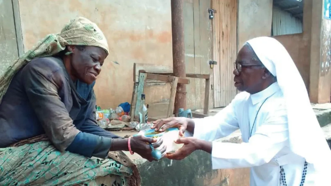 A Sister helping a displaced woman in Nigeria