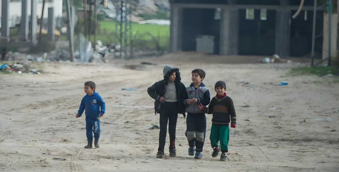 4 young boys walking an unpaved road in the Holy Land