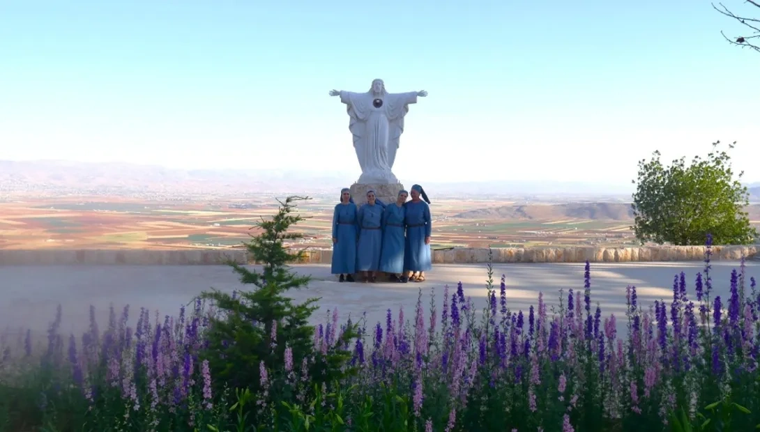 The Sisters of Jesus Abandoned standing by a statue of Jesus in Lebanon