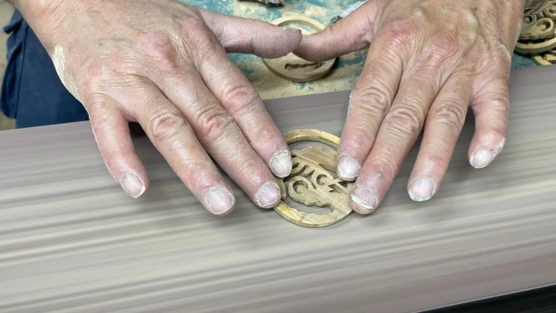 Sanding down an olive wood Christmas decoration