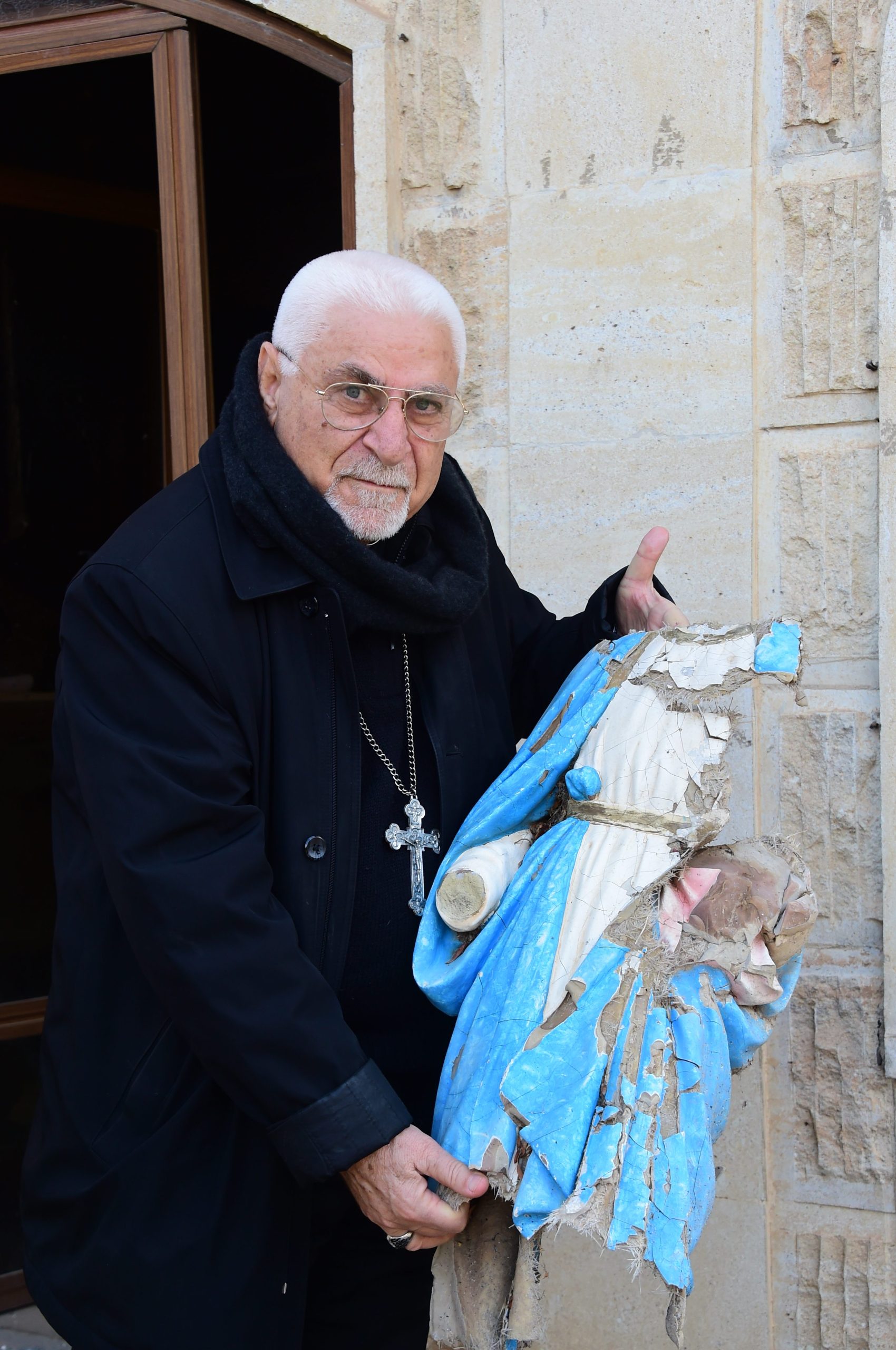 Archbishop Petros Mouche of Mosul at Saint George Syriac-Catholic Church holding a statue of Our Lady damaged by Daesh (© Aid to the Church in Need)