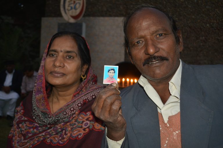 Nazbano and Bashir holding up a picture of their son, Akash Bashir, aged 20, who gave his life preventing a suicide bomber from entering the church compound.