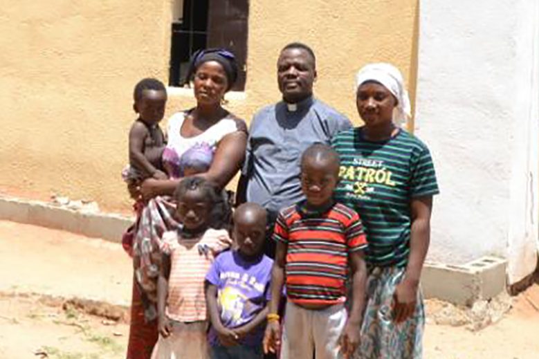 Bereaved families with priest in Asso village, Kaduna state, Nigeria: Mrs Blessing Stephen (left) with children Goodwin, Emmanuelle, Miracle, Father Alexander Yeyock, Mrs Evelyn Martins and son, Humble (© ACN-Fr A Yeyock)
