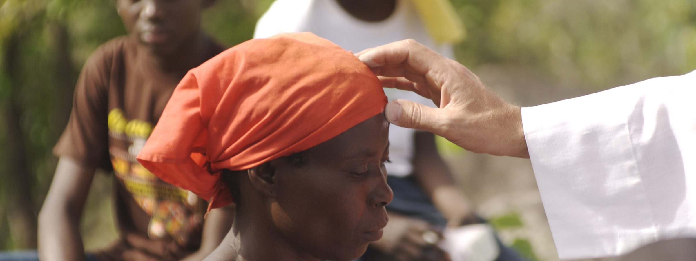 Central African Republic, Bozoum, priest placing a cross of ashes on a woman's forehead on Ash Wednesday