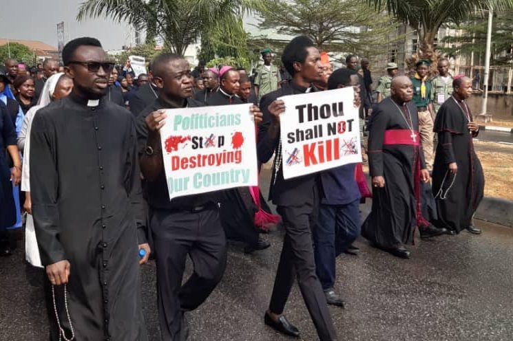 Catholic bishops in Nigeria lead a peaceful protest; Father Sebastain Sanni holds a placard saying “Thou shall not kill” during the march (Credit: Aid to the Church in Need)