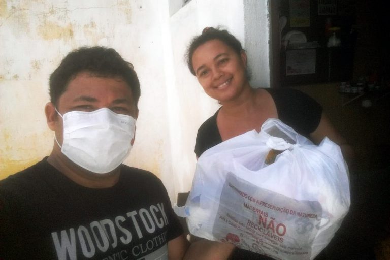 A lay member of Brazil's Shalom Community delivers a food parcel during the pandemic
