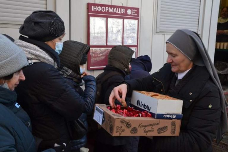 With picture of a Sister distributing urgent relief to those in need (© ACN)