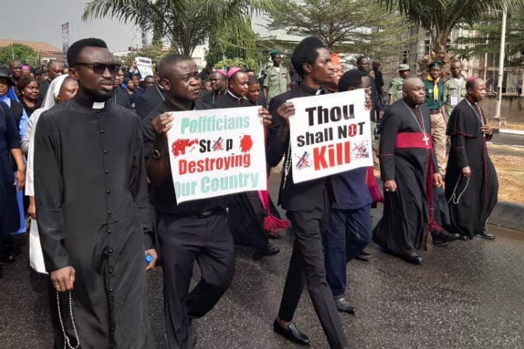 With picture of Catholics protesting the killing of Christians in 2020 (© Aid to the Church in Need)