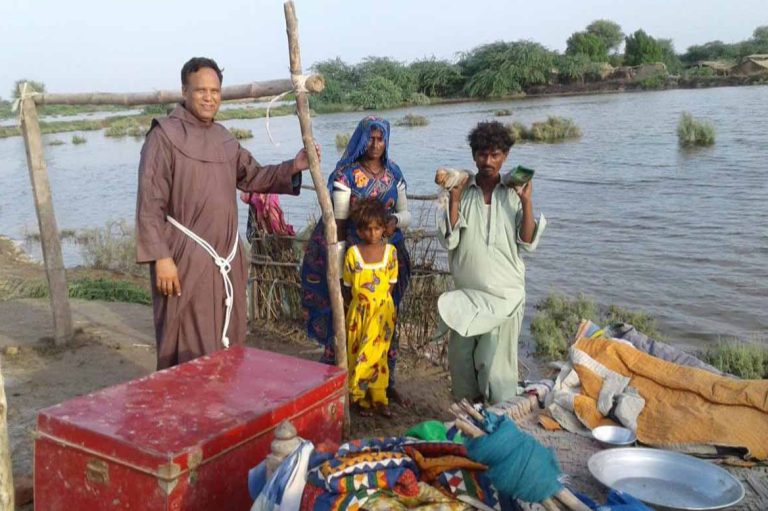 A Franciscan friar with flood victims in Khipro, Sindh (© Aid to the Church in Need)