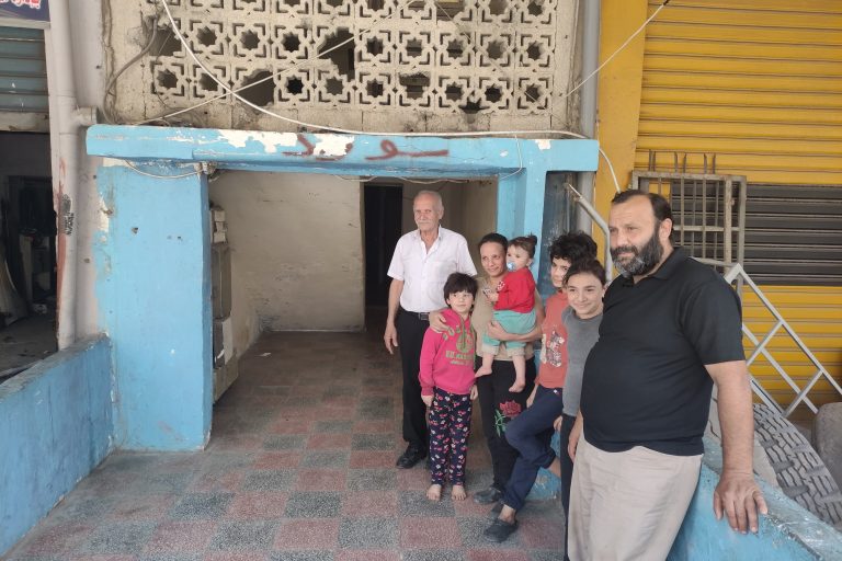 Salim Assaf, with his family, outside the one-bedroom flat he lives in with his wife, four daughters and his father. The crisis in Lebanon has been devastating for families like his (© ACN).