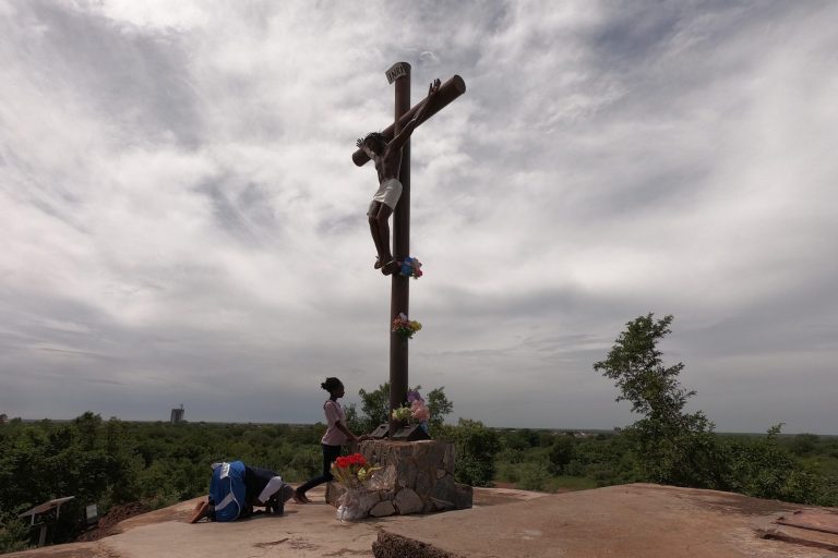 Pilgrims praying before the cross at the Shrine of Our Lady of Yagma, Burkina Faso.