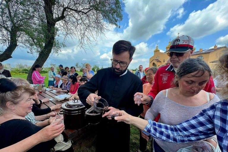 Father Ihnatij Moskalyuk providing sustenance for the local people.