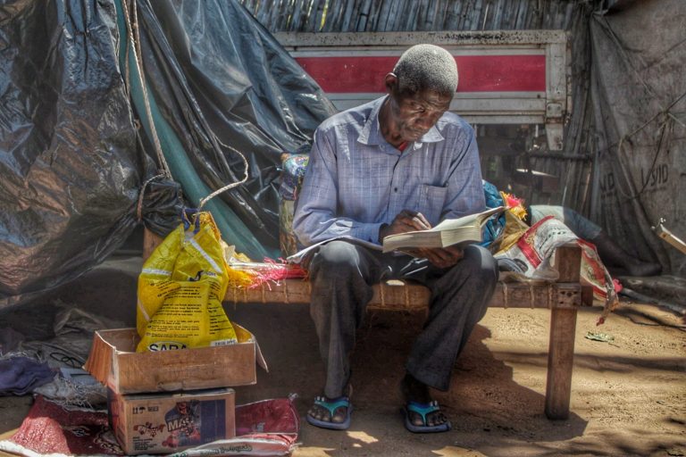 A man in Mozambique reading the Bible.
