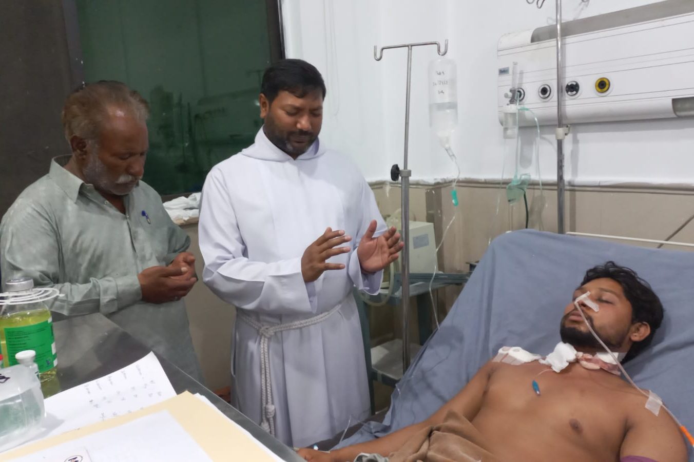 Father Lazar Aslam visiting Waqas Masih in hospital.